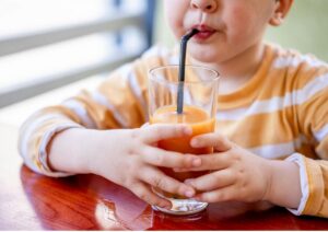 ストローでジュースを飲む子供の画像